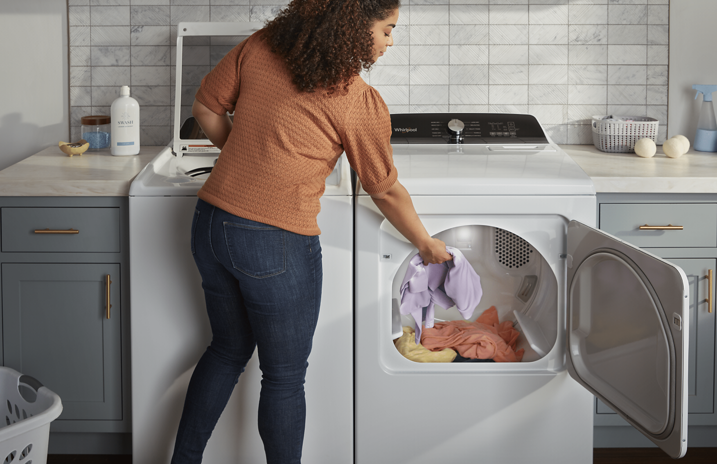 Person loading towels into a Whirlpool® dryer