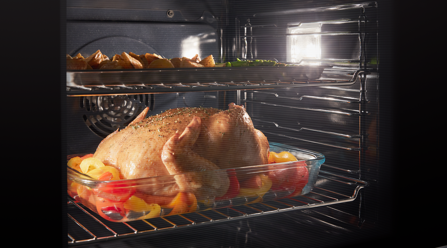 Chicken and vegetables roasting in an oven