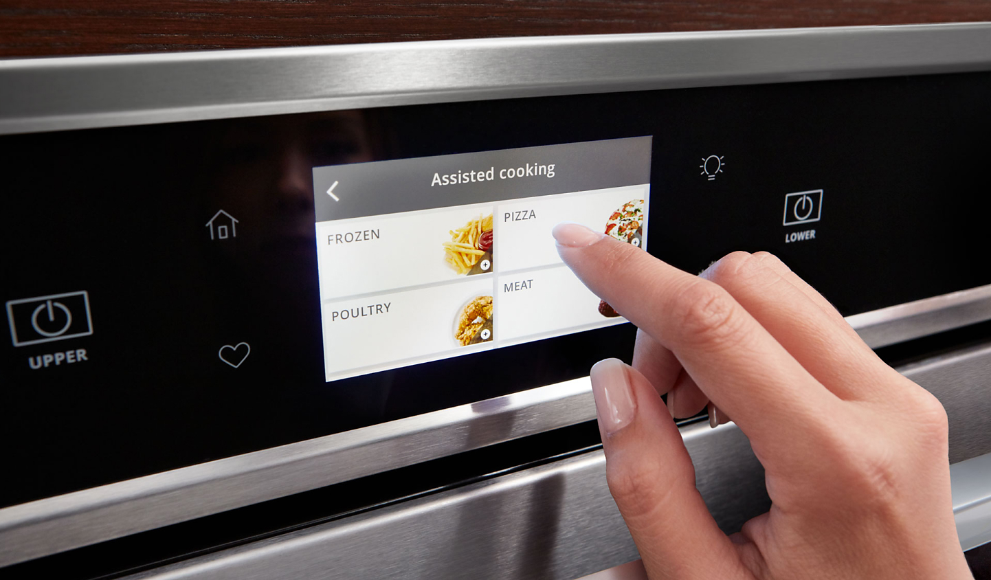 Close up of person’s hand selecting cooking options on wall oven menu 