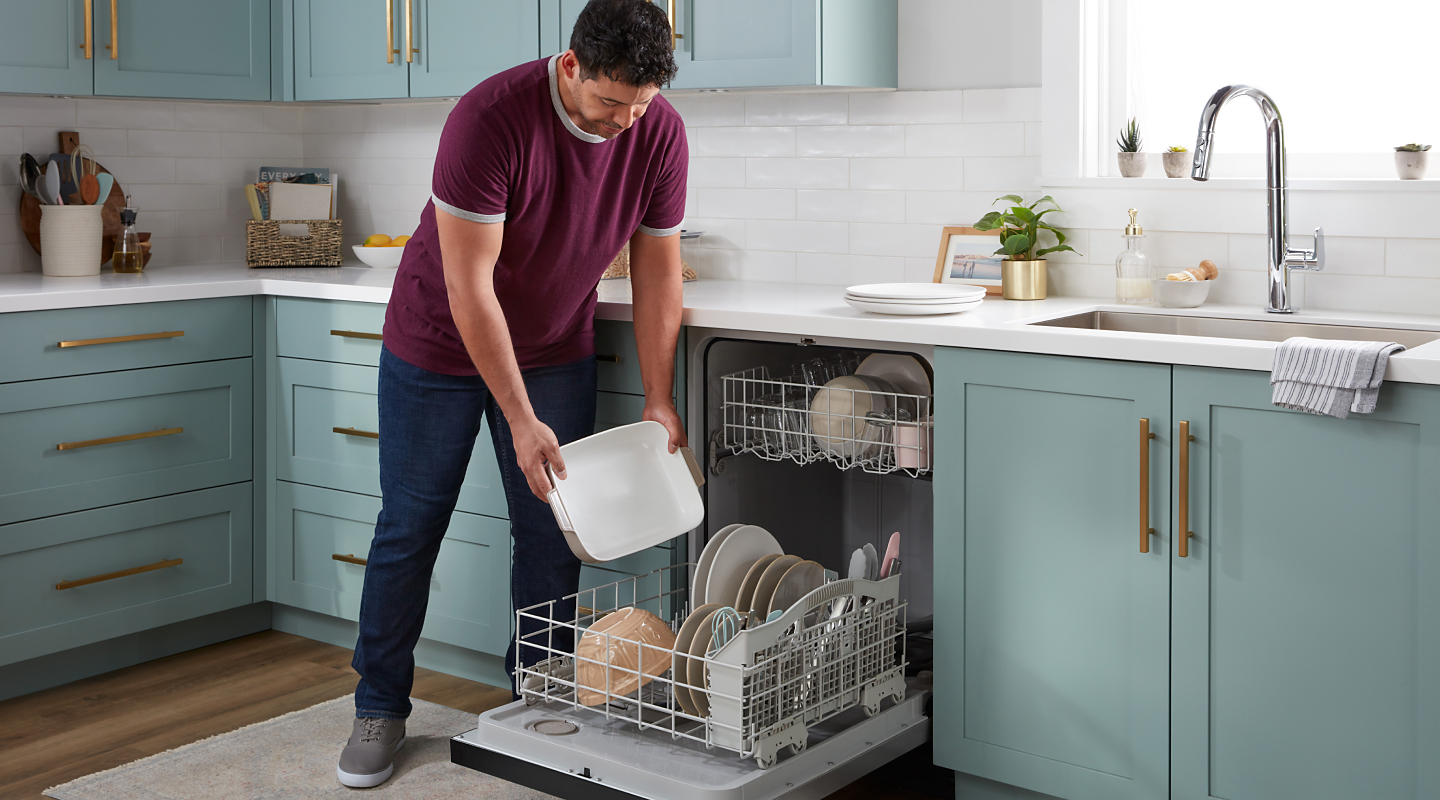 Person loading plate into dishwasher