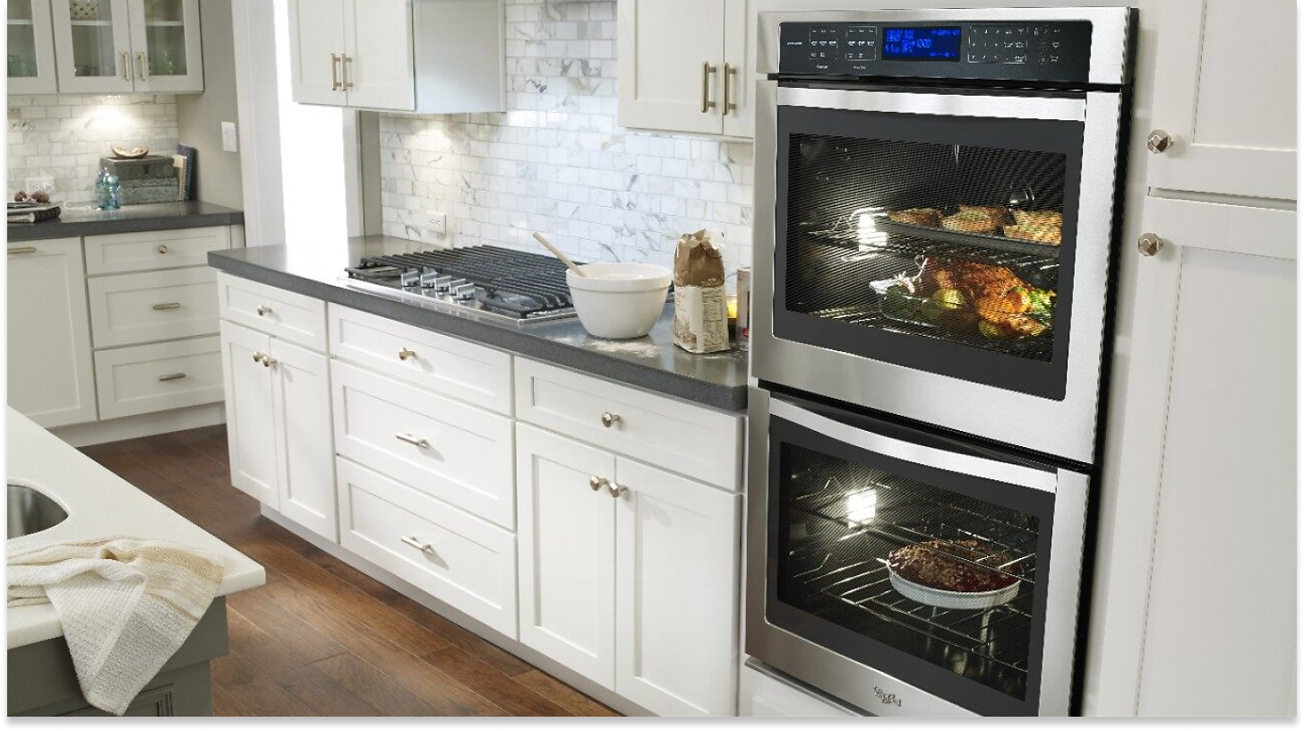 Double wall oven in white cabinetry with food inside.