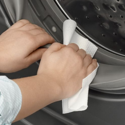 Person wiping rubber seal on washing machine door