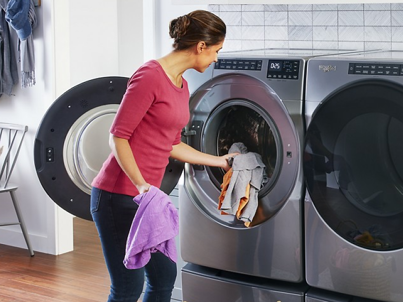 Person loading front load washing machine