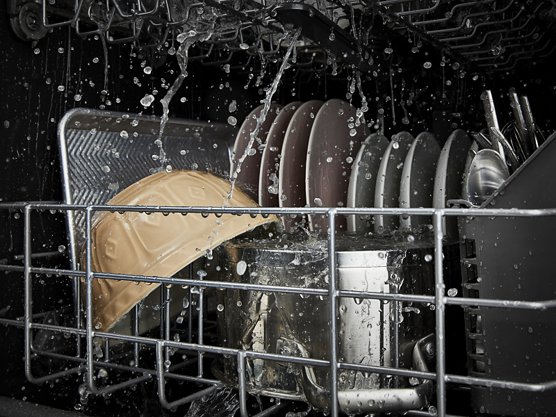 Dishes being rinsed in a dishwasher