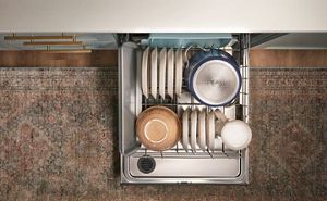 Open Whirlpool® dishwasher showing both racks fully loaded