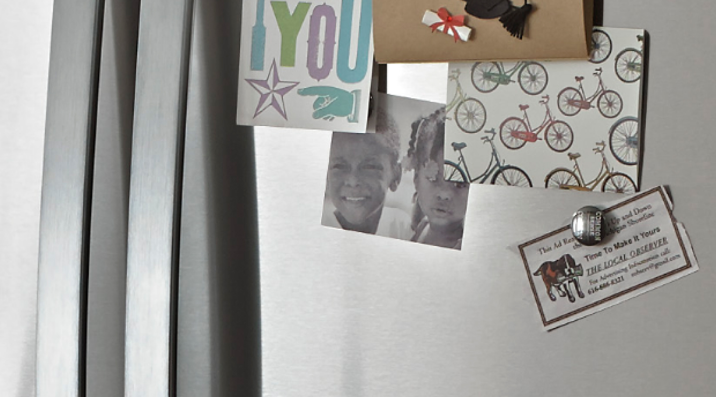 一张用磁铁贴在冰箱上的卡片和照片的特写