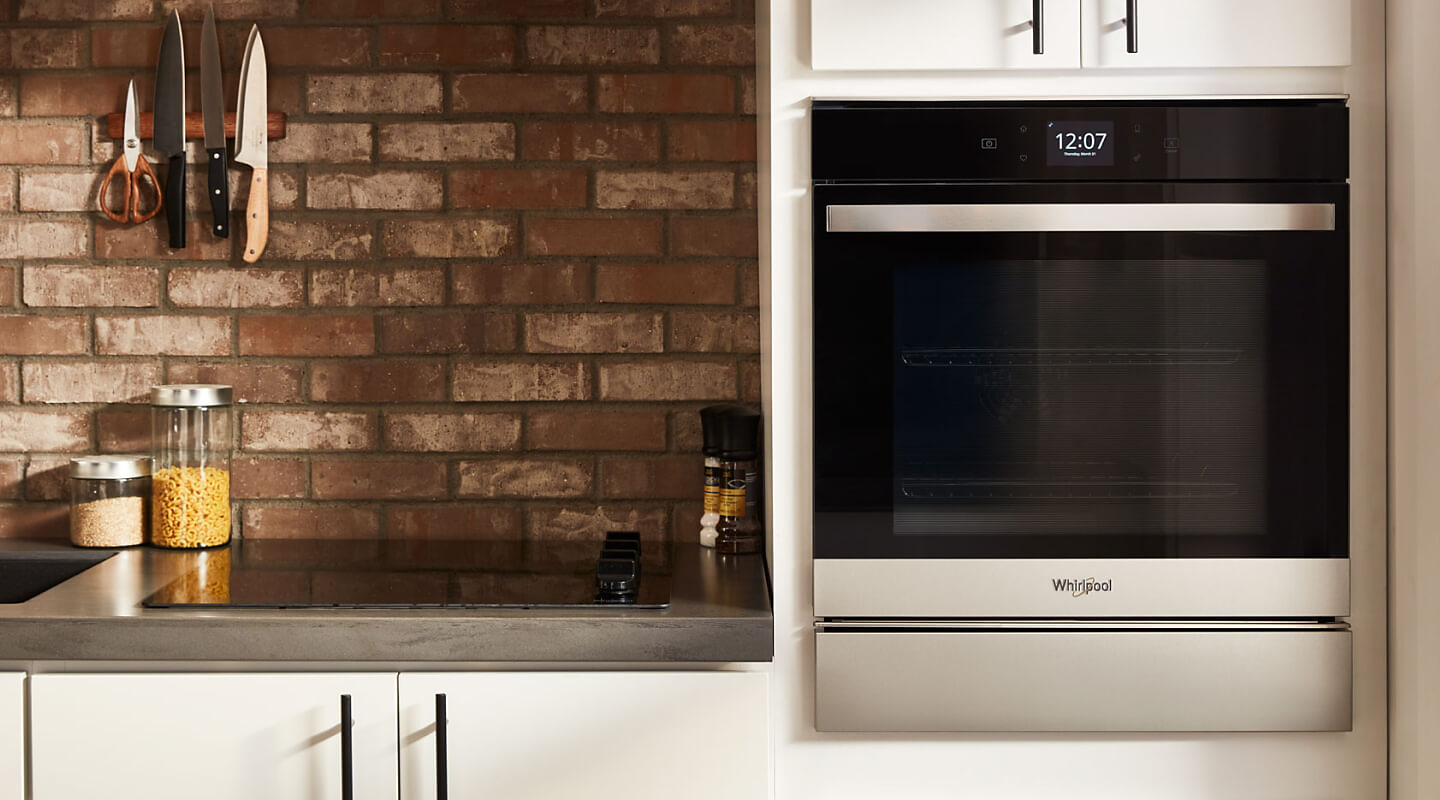 Stainless steel Whirlpool® wall oven in a rustic kitchen