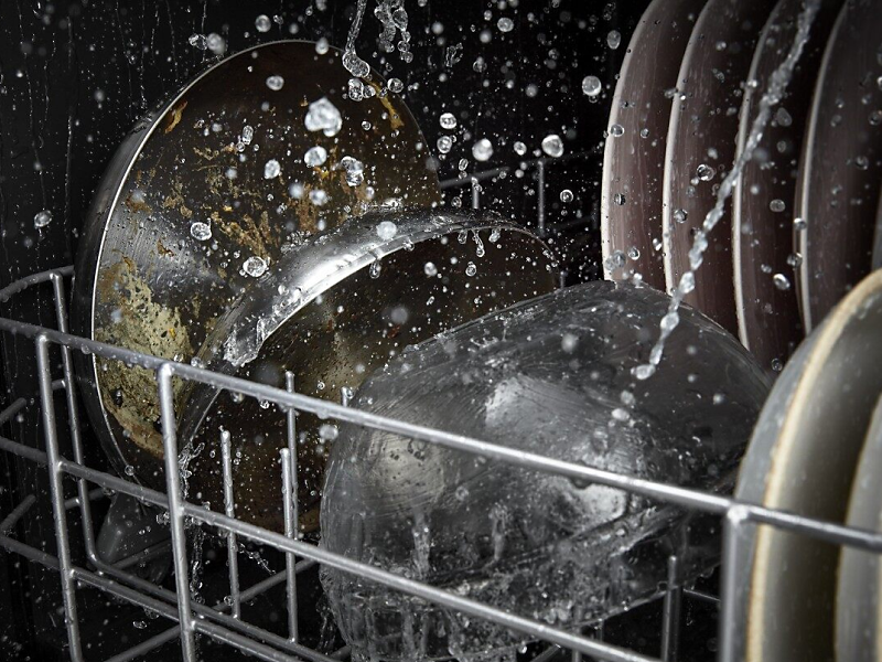 Dirty dishes going through a dishwasher cycle