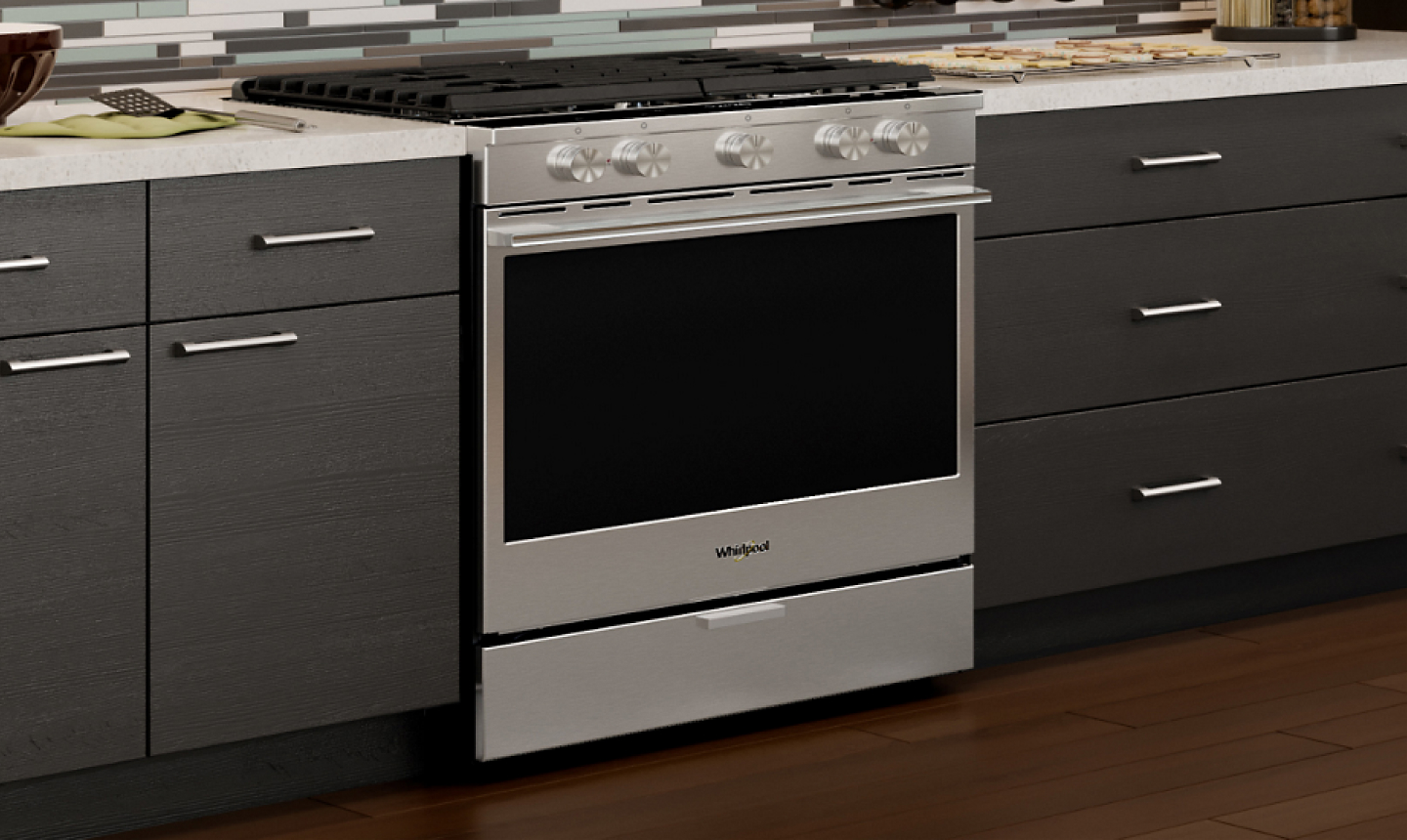 Silver gas stove from Whirlpool brand surrounded by brown cabinetry