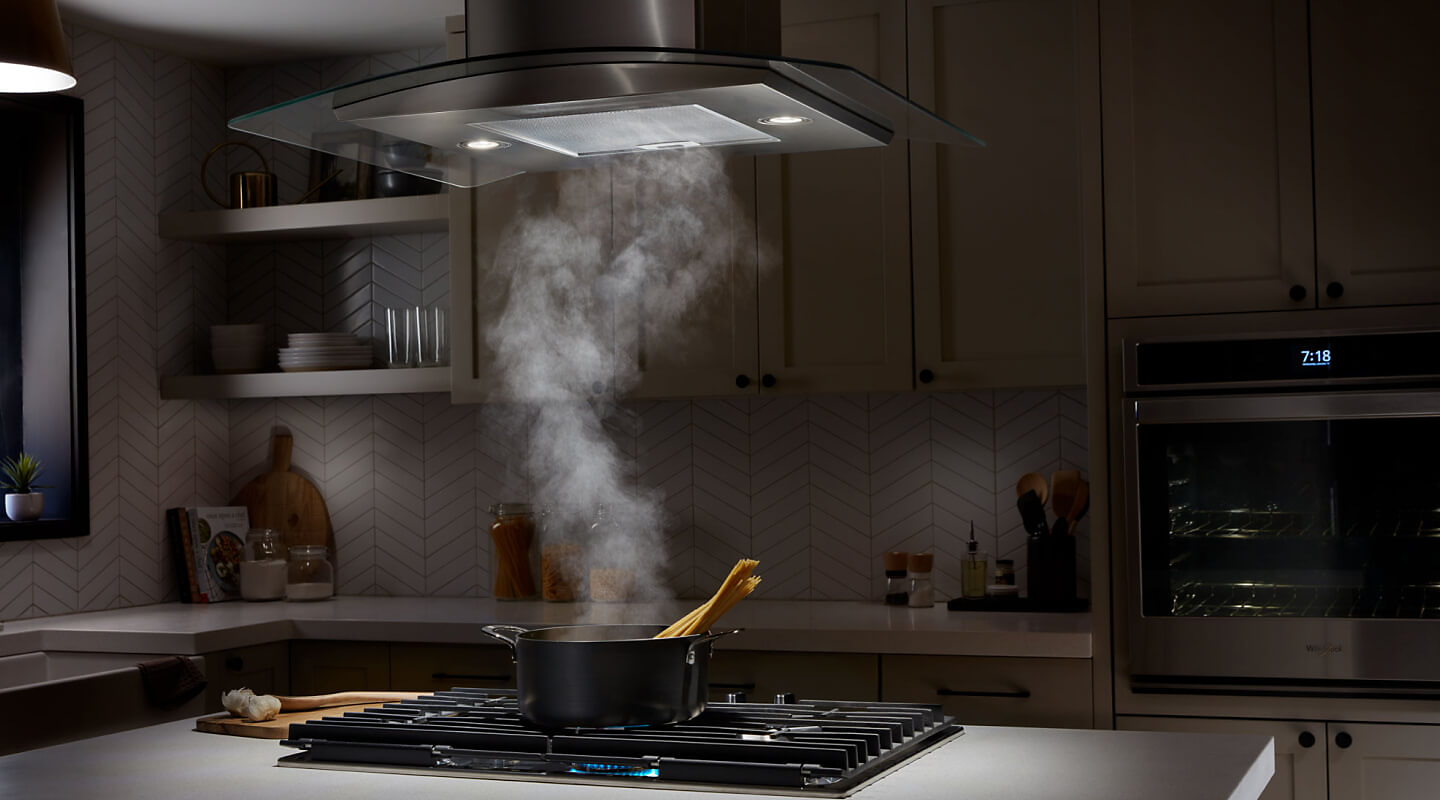 Smoke from a pot being drawn up into a range hood