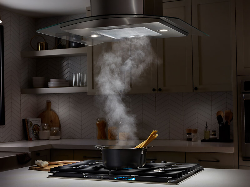 Smoke from a pot being drawn up into a range hood