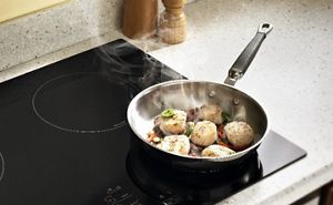 Scallops cooking in a frying pan on a cooktop