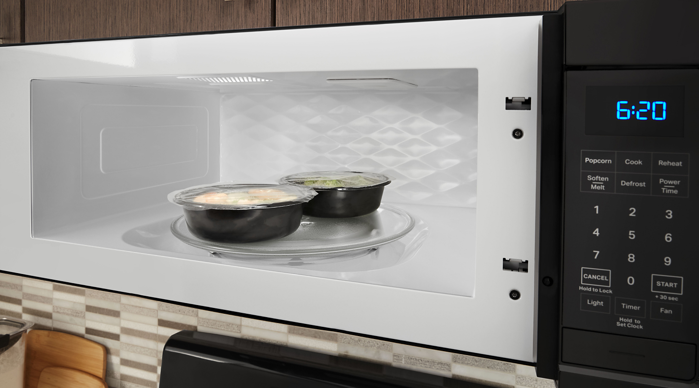 Two single-serve frozen meals inside of an open microwave