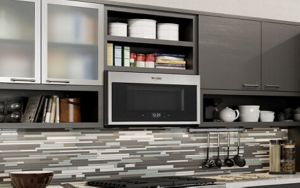 A Whirlpool® microwave installed over a gas range