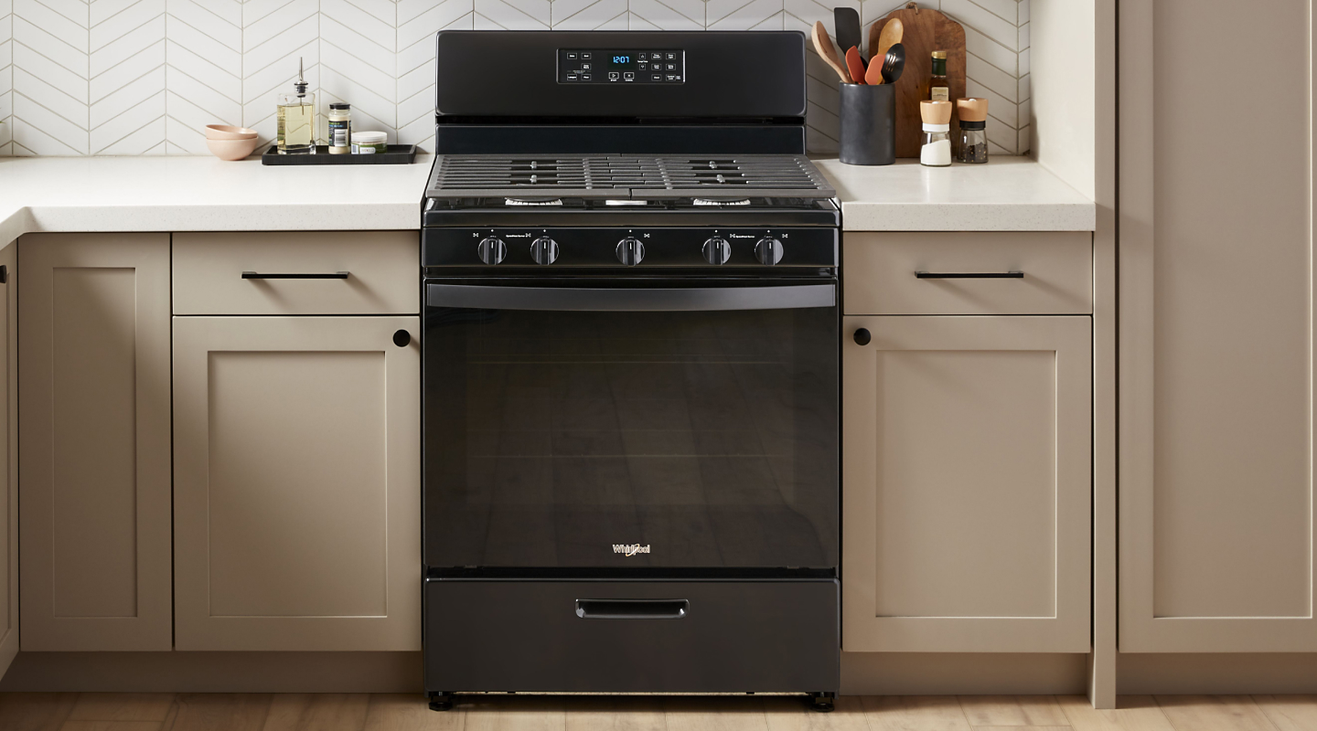 Black Whirlpool® Gas range in a kitchen with neutral backsplash and countertops
