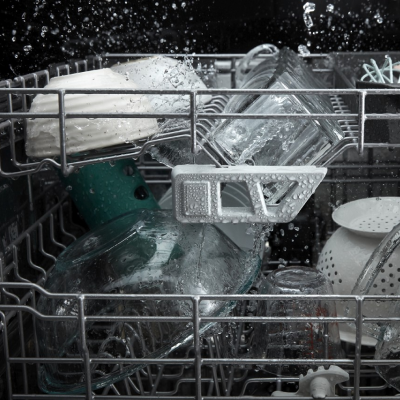A closeup of the interior racks of a Whirlpool® dishwasher during a wash cycle.