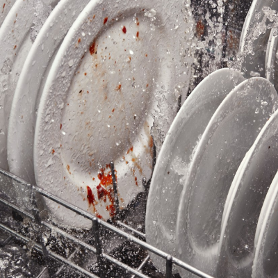 A closeup of the bottom rack of a Whirlpool® dishwasher washing plates during a wash cycle.