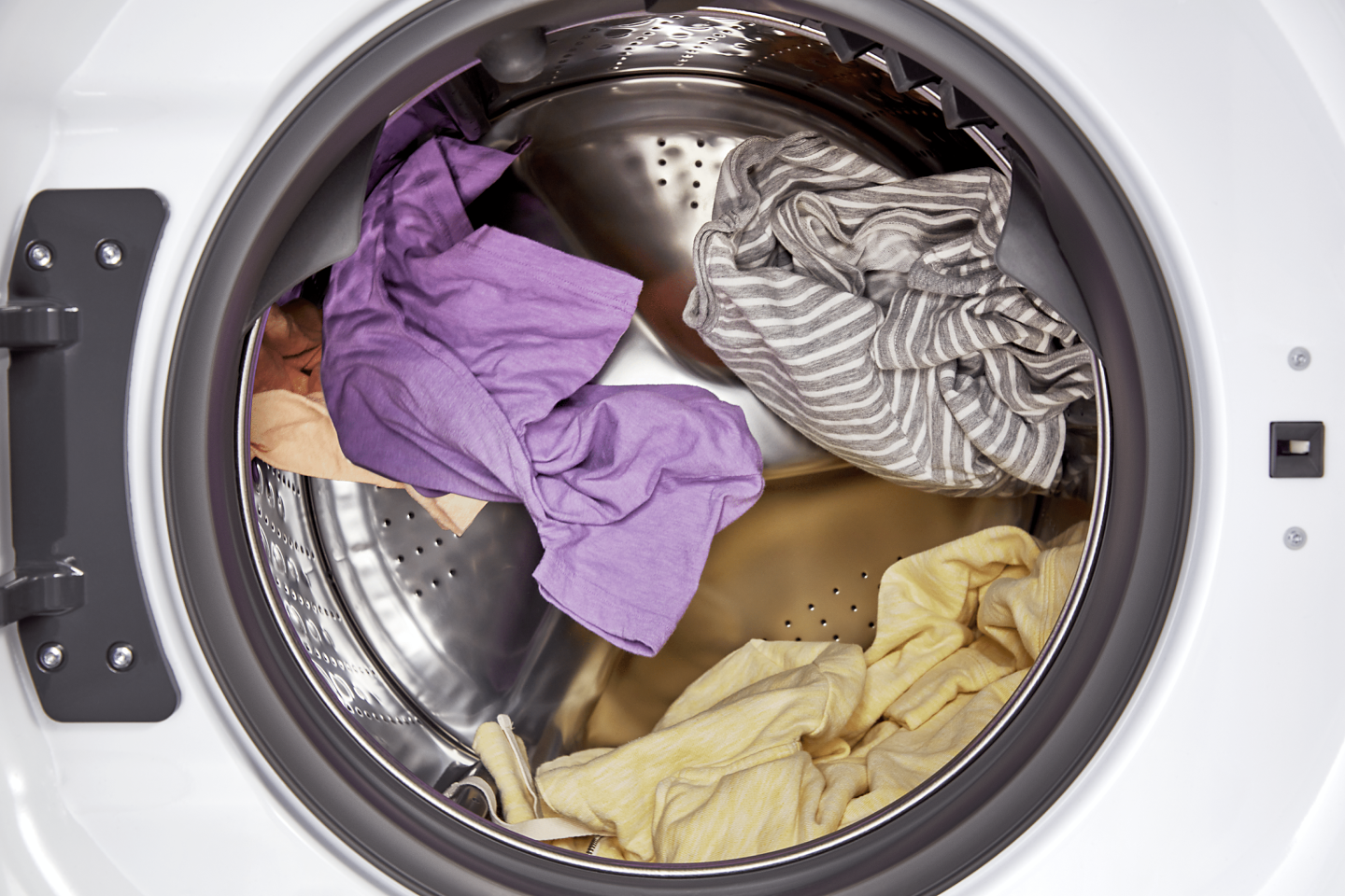 Interior shot of clothes tumbling in a dryer drum.