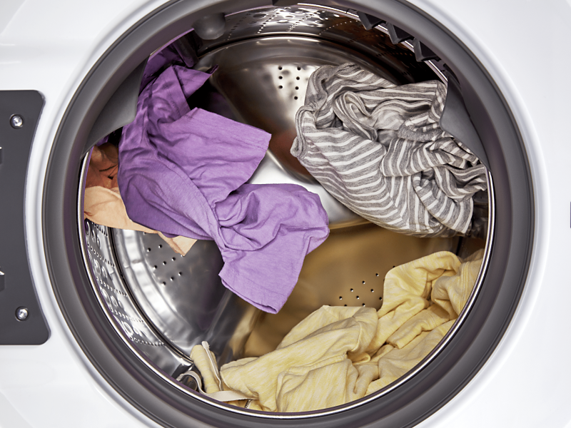Interior shot of clothes tumbling in a dryer drum.