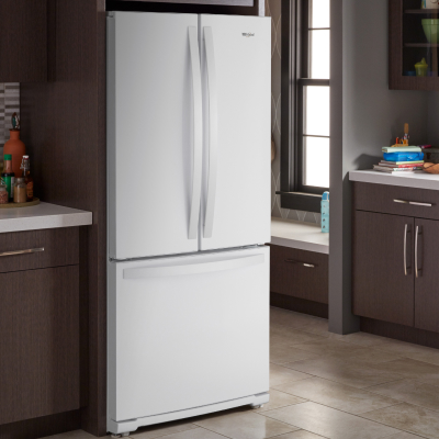 White Whirlpool® French door refrigerator in brown cabinetry