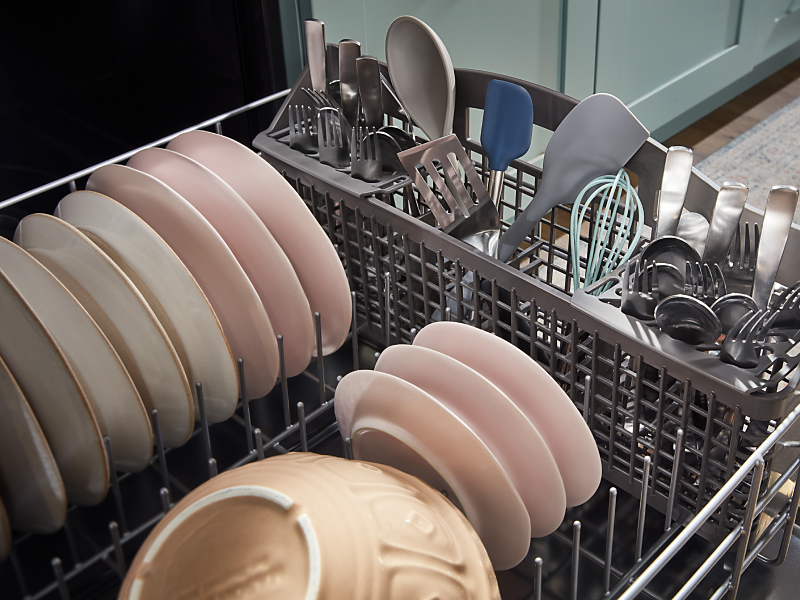 The bottom rack of a Whirlpool® dishwasher filled with dishes.