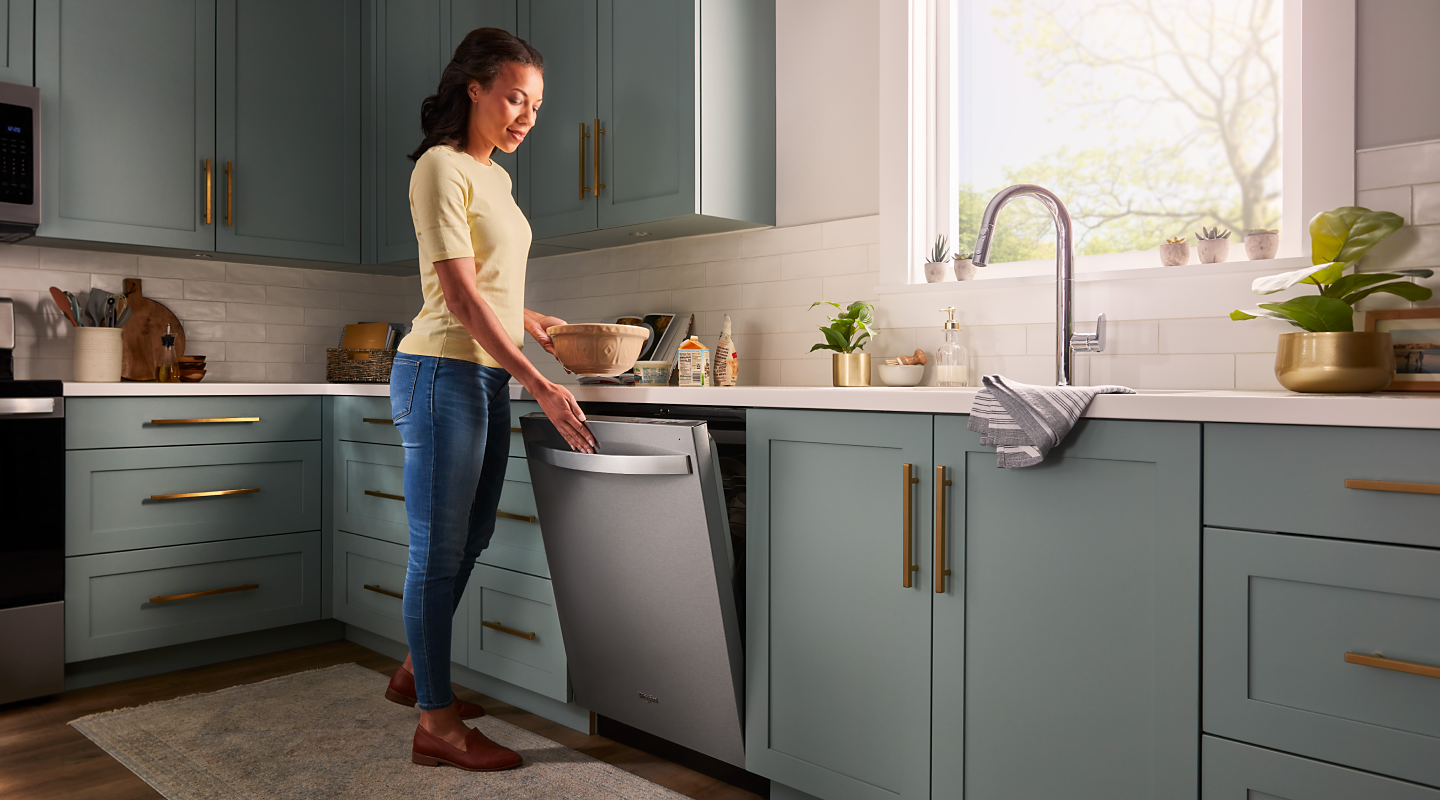 Person closing a Whirlpool® top control dishwasher