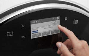 A hand setting a wash cycle on a front load washer