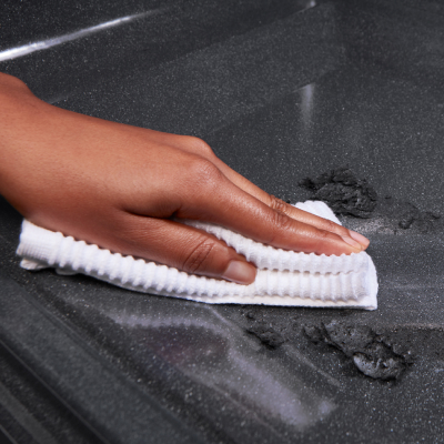 A hand scrubbing the oven