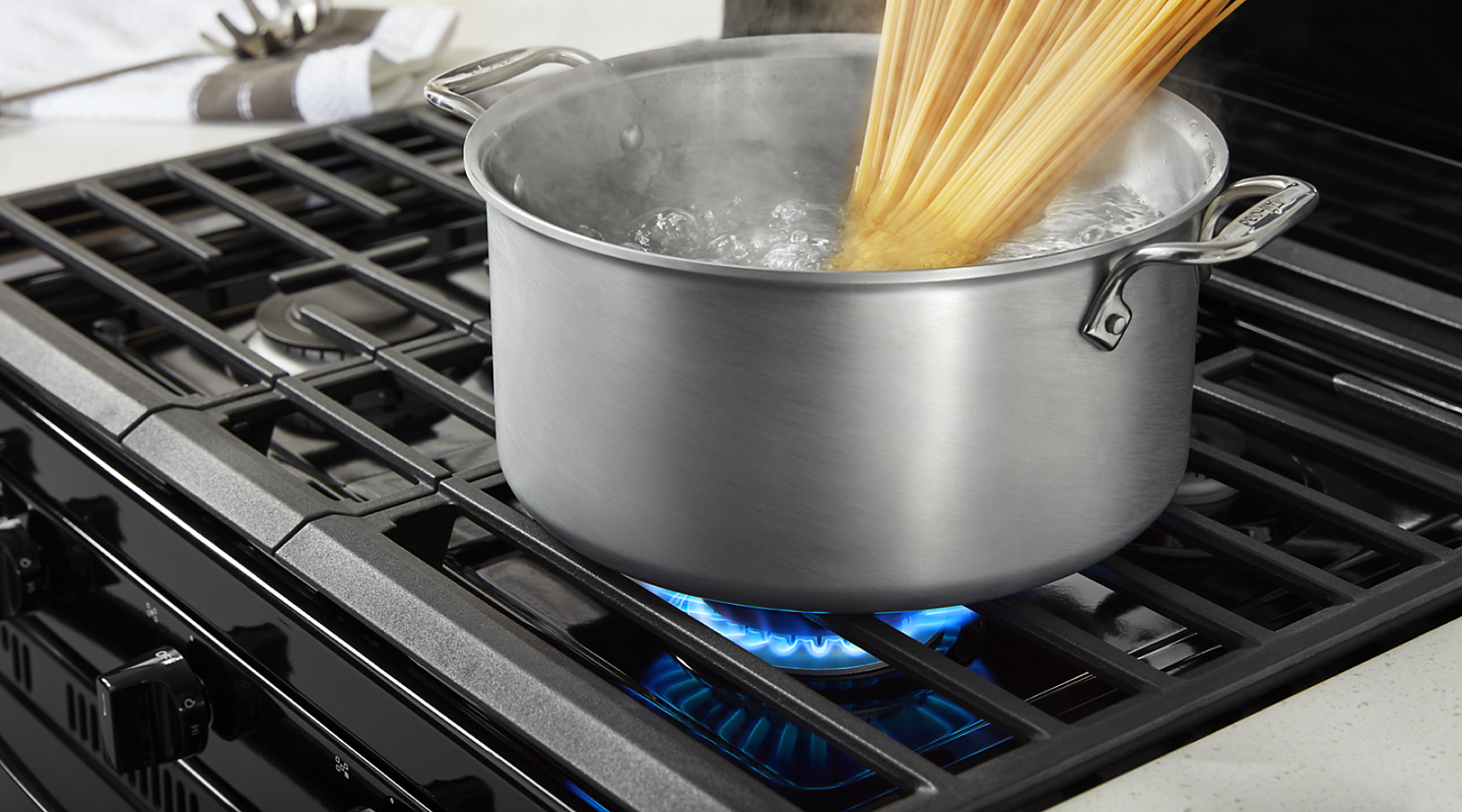 Pasta boiling in a pot on a gas range burner
