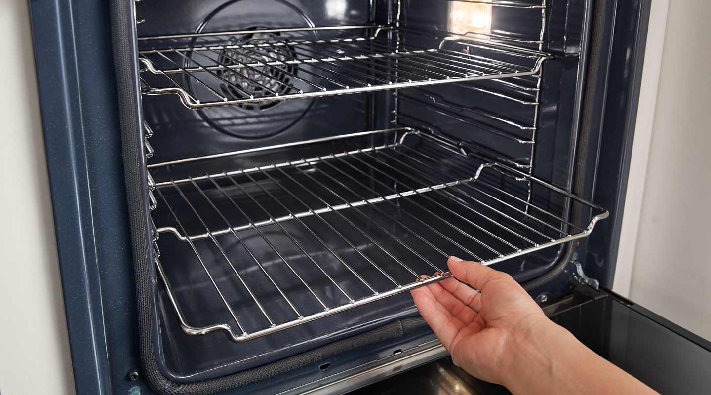 Person removing an oven rack from a Whirlpool® oven