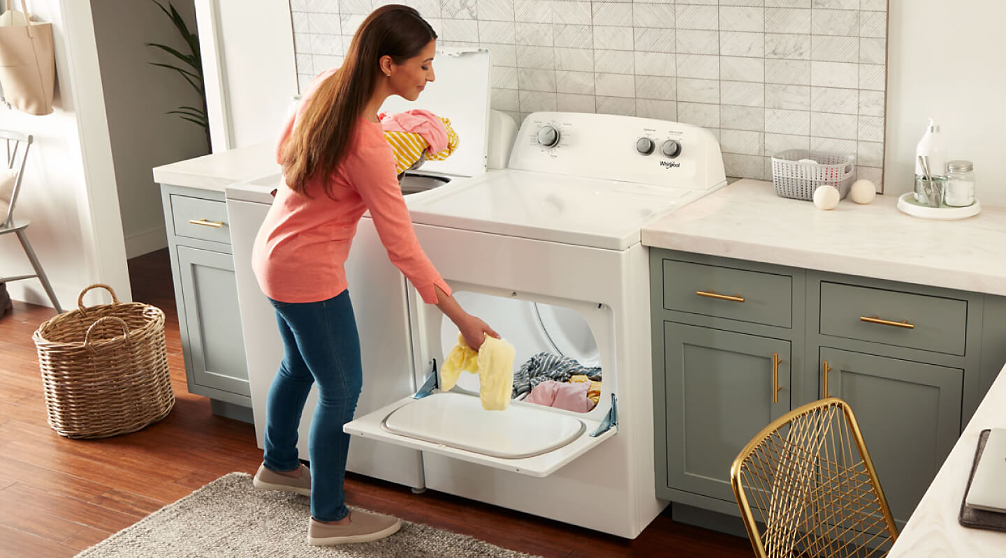 Woman loading clothes into a Whirlpool® dryer