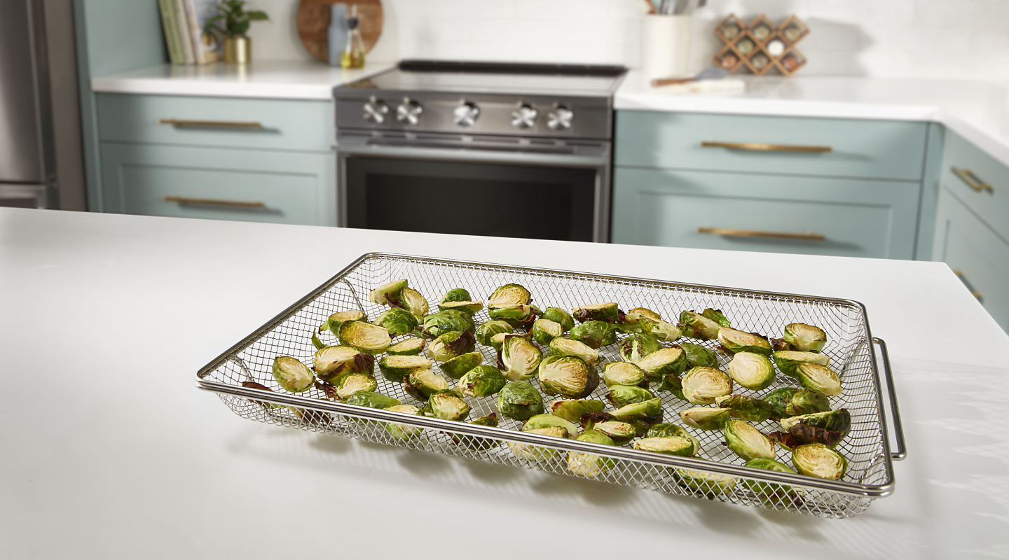 Oven air fried brussel sprouts on air fryer basket on counter