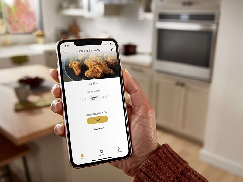 A closeup of a person holding a phone showing an online air fry recipe.