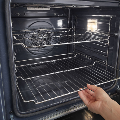 A hand inserting an oven rack