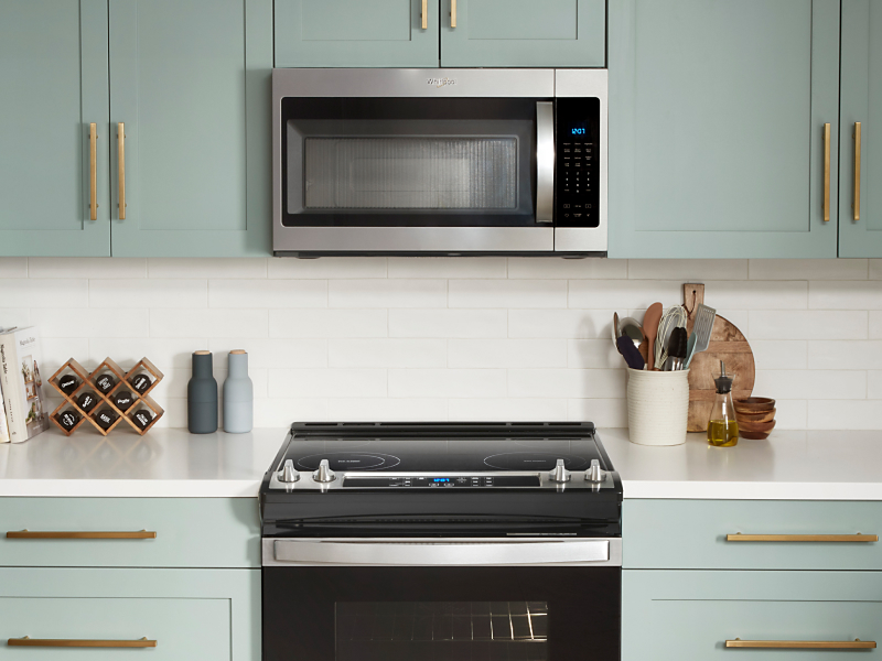 Over-the-range microwave above electric stove in light blue cabinetry