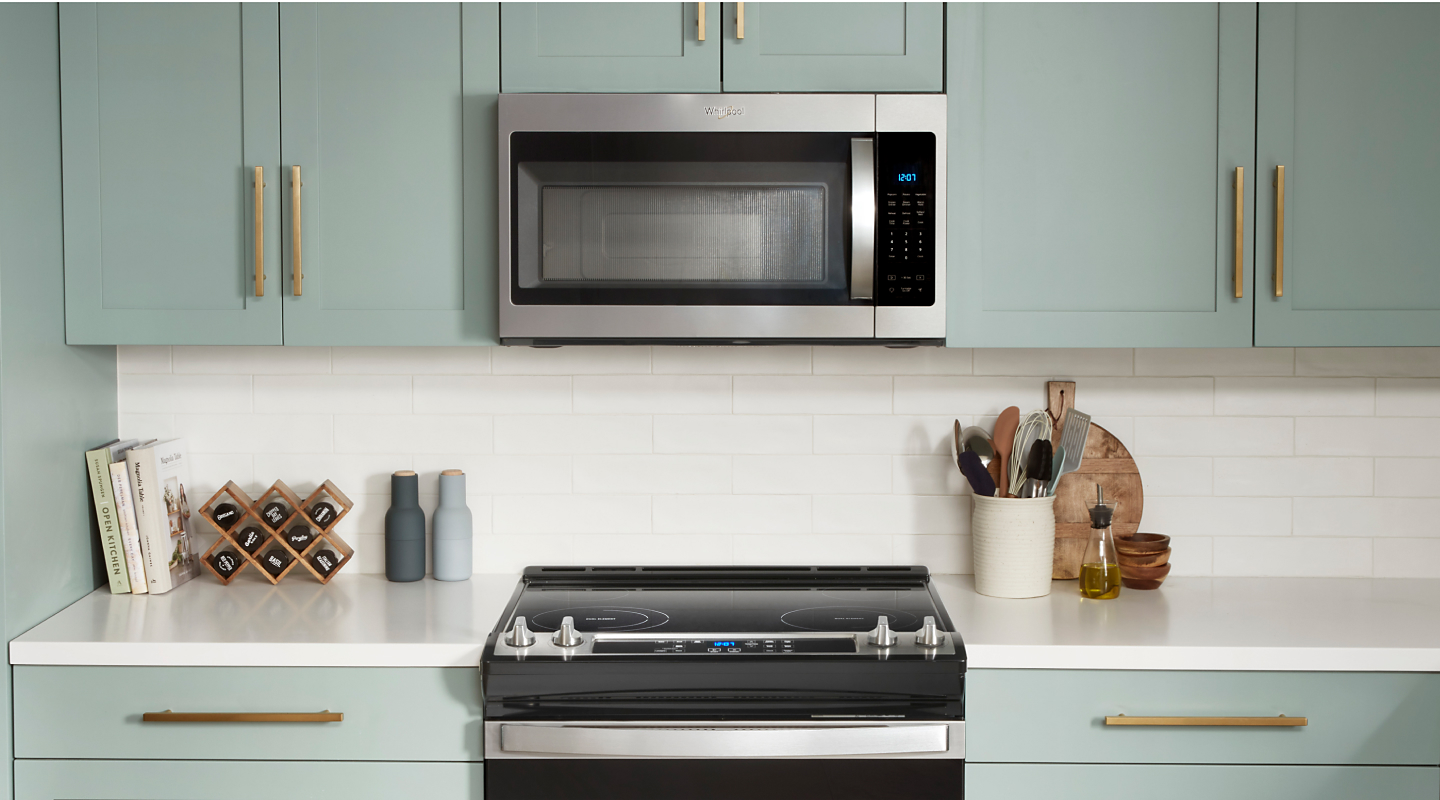 Over-the-range microwave above electric stove in light blue cabinetry