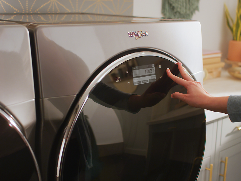 Person selecting a cycle on a Whirlpool® front-load dryer