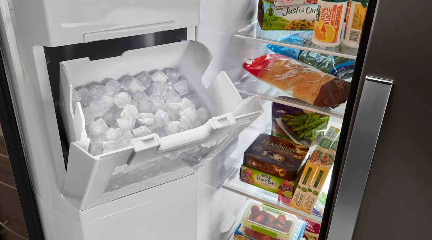 An open ice maker filled with ice