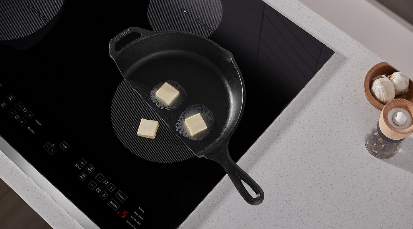 Butter in a cast iron pan melting on a Whirlpool® induction cooktop.
