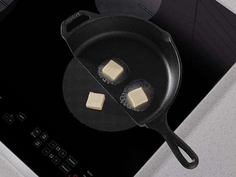 Butter in a cast iron pan melting on a Whirlpool® induction cooktop.