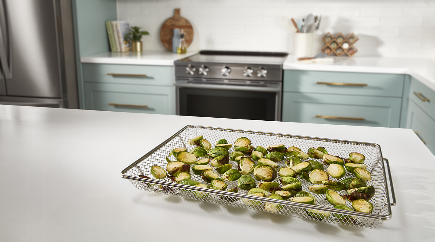 Sliced Brussels sprouts inside an air fryer basket