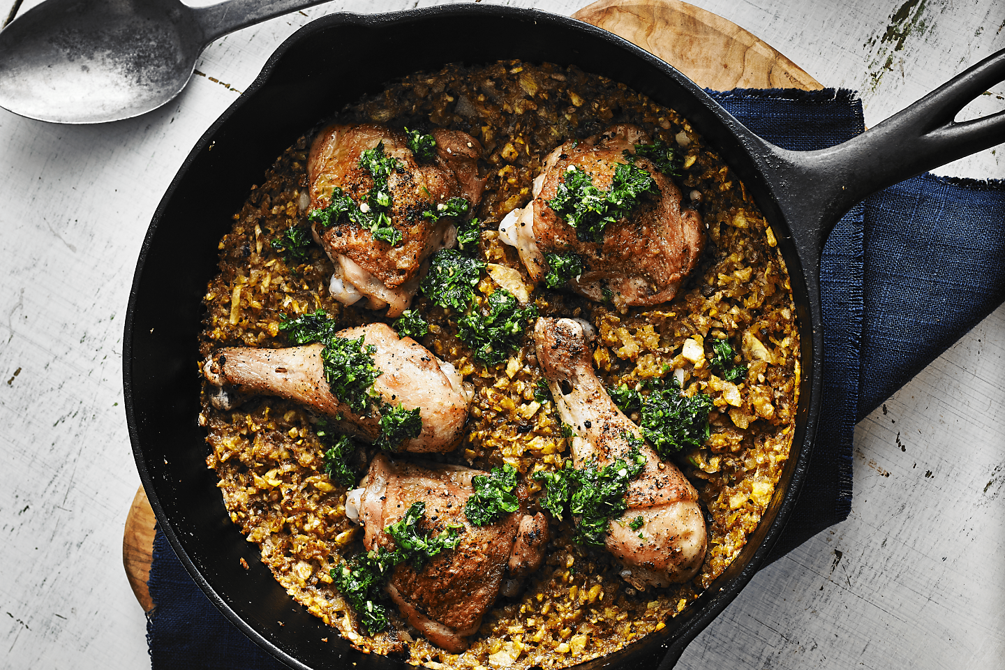 Cast iron skillet filled with baked chicken and rice medley
