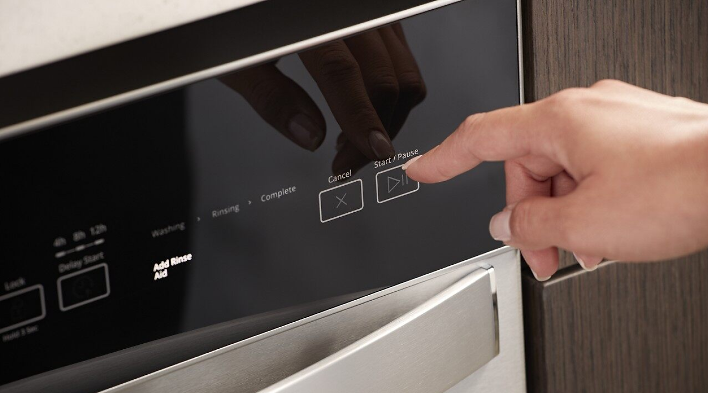 Person selecting a dishwasher wash cycle