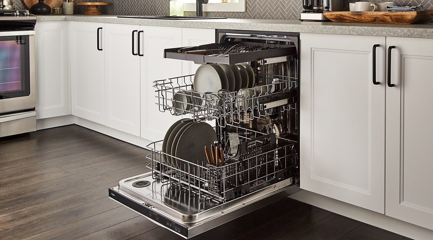An open dishwasher with all of the racks full of dishes