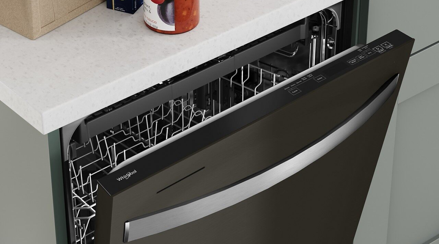 An aerial view of a Whirlpool® dishwasher opened just enough to see the top rack