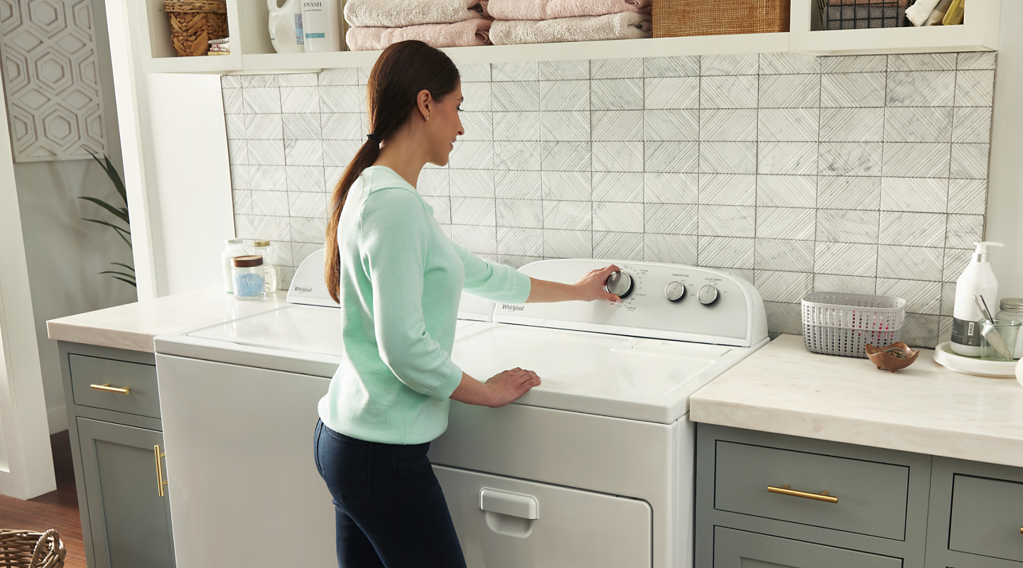 Woman selecting laundry cycle settings