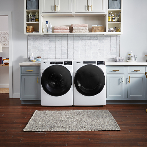 White front-loading washer and dryer in a modern laundry room
