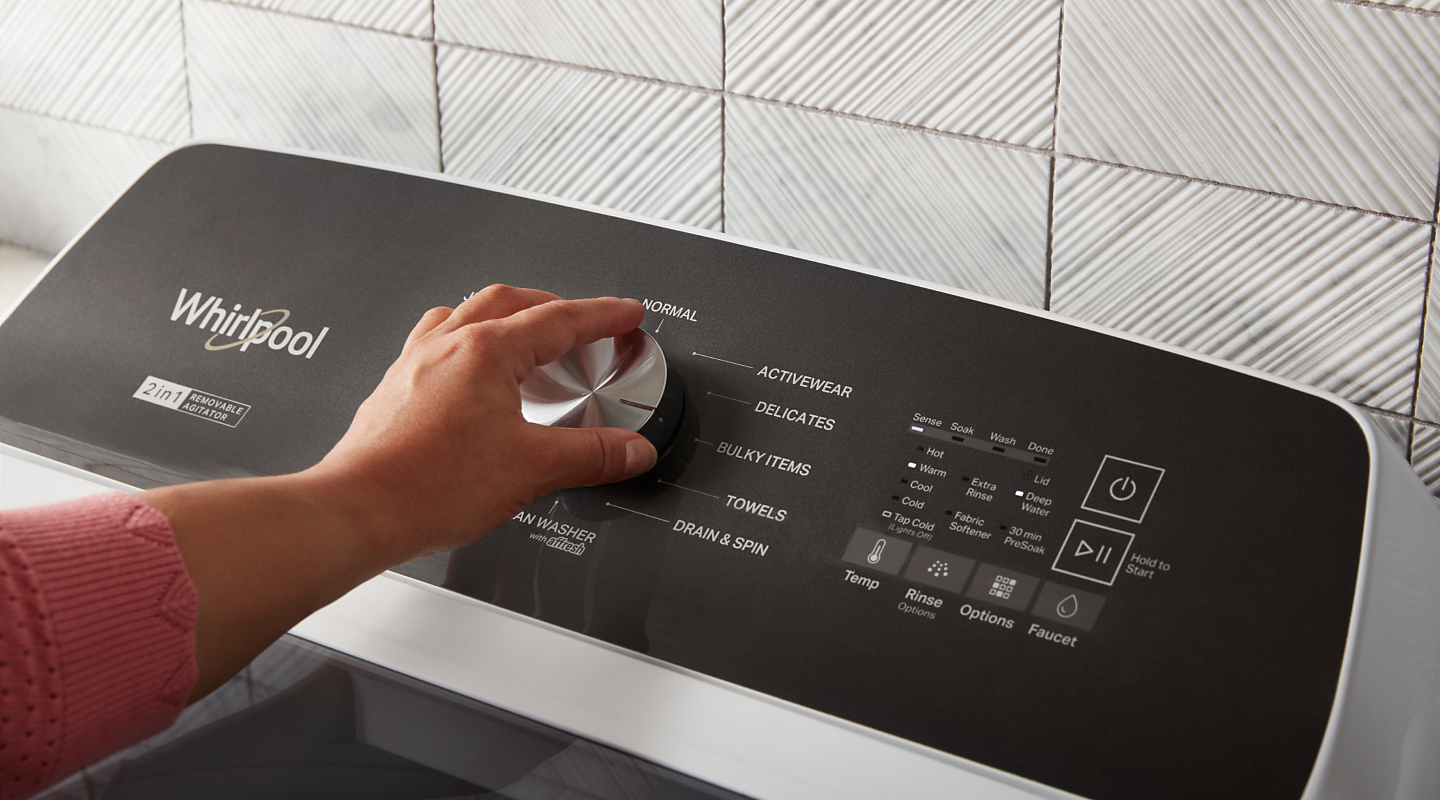 Person selecting a cycle on a Whirlpool® washing machine