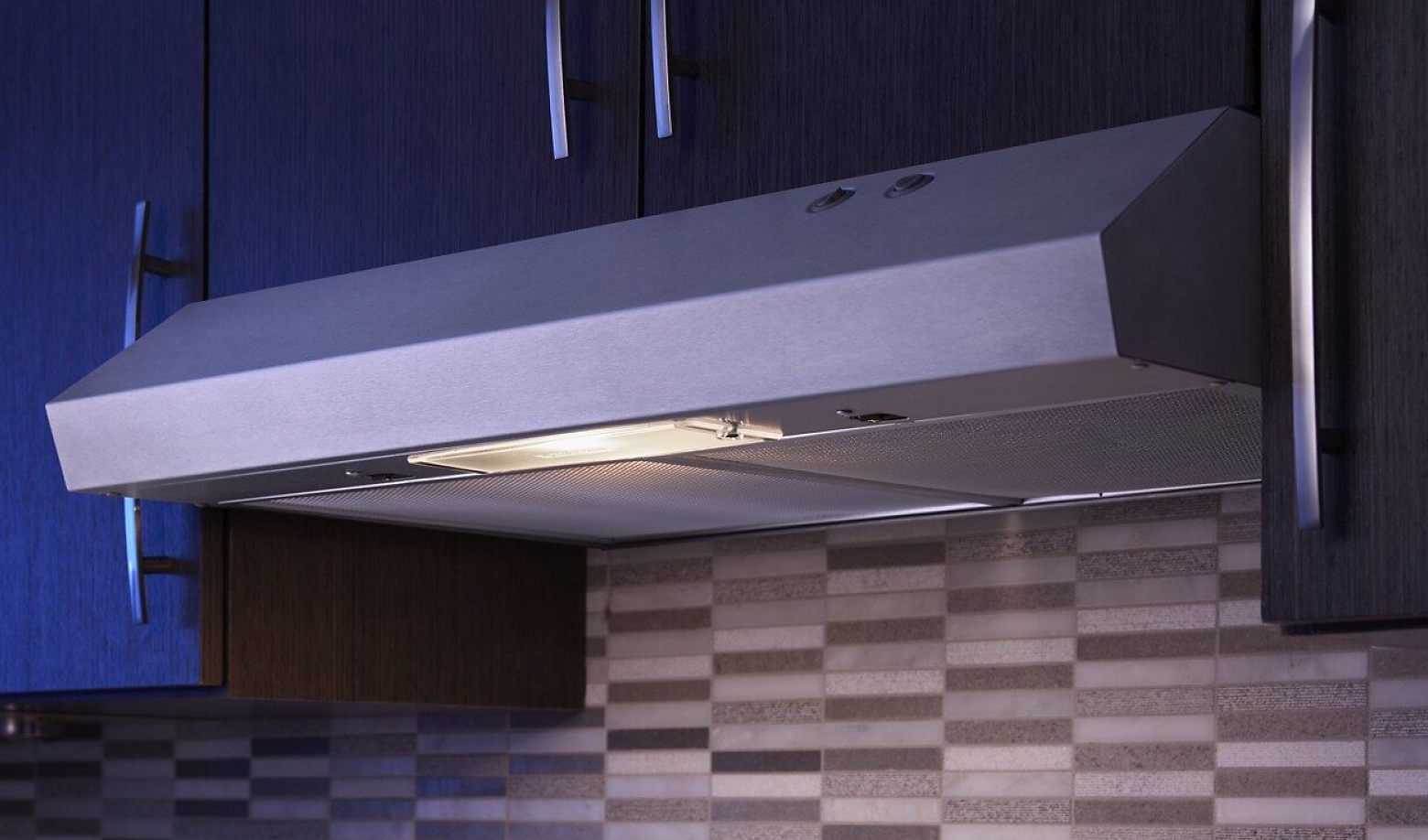 Range hood between dark cabinets with light on