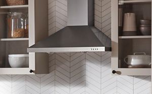 Range hood between white cabinets